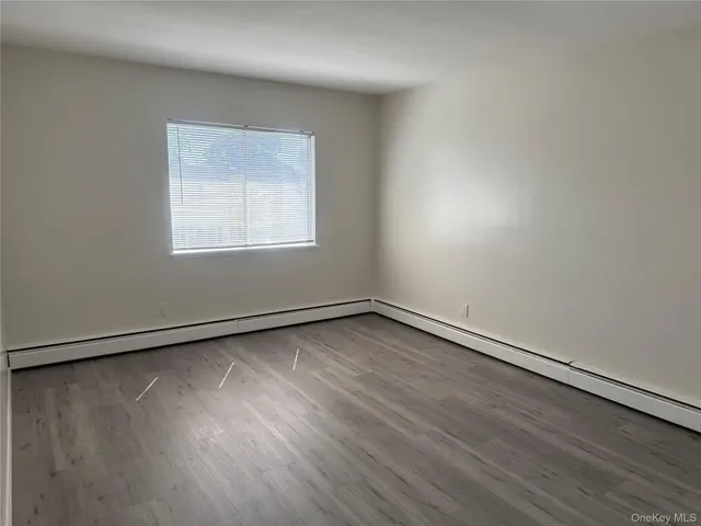an empty room with a hardwood and a window