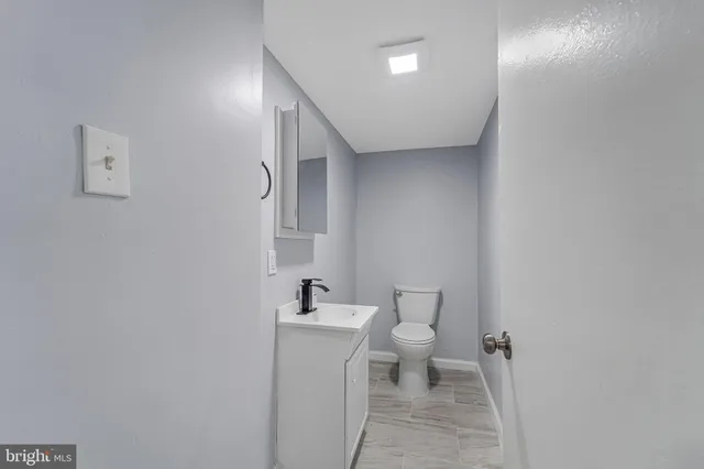 a bathroom with a toilet a sink and mirror