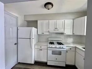 a kitchen with white cabinets and white appliances