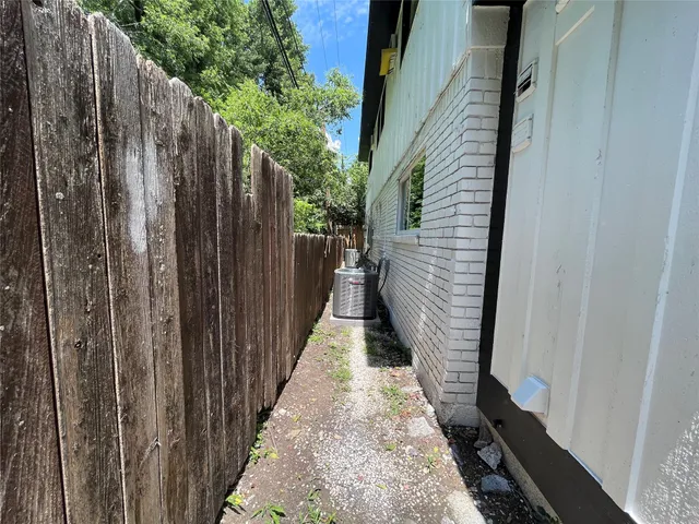 a view of a pathway of a house with wooden fence
