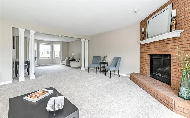 a view of a dining room and livingroom with furniture wooden floor a chandelier