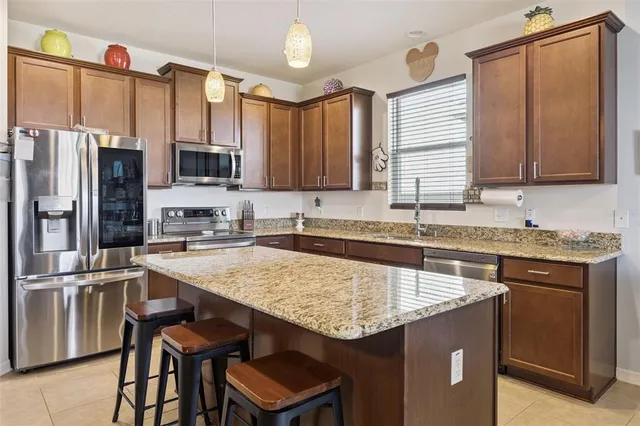 a kitchen with granite countertop a sink stove and refrigerator
