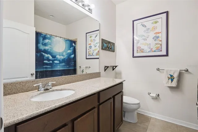 a bathroom with a granite countertop sink mirror and toilet