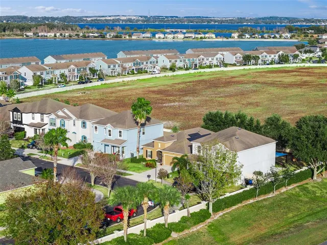 an aerial view of ocean and residential houses with outdoor space