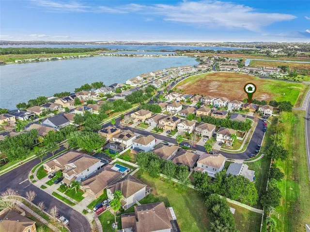 an aerial view of ocean and residential houses with outdoor space
