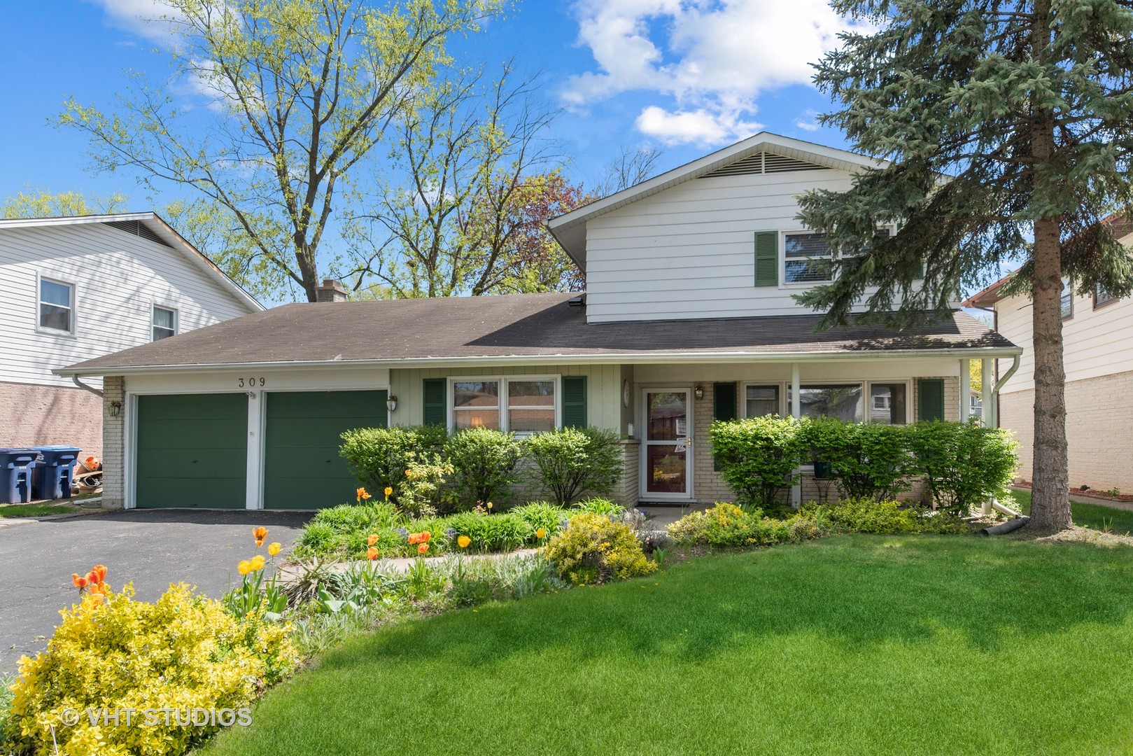 a front view of a house with a yard and potted plants