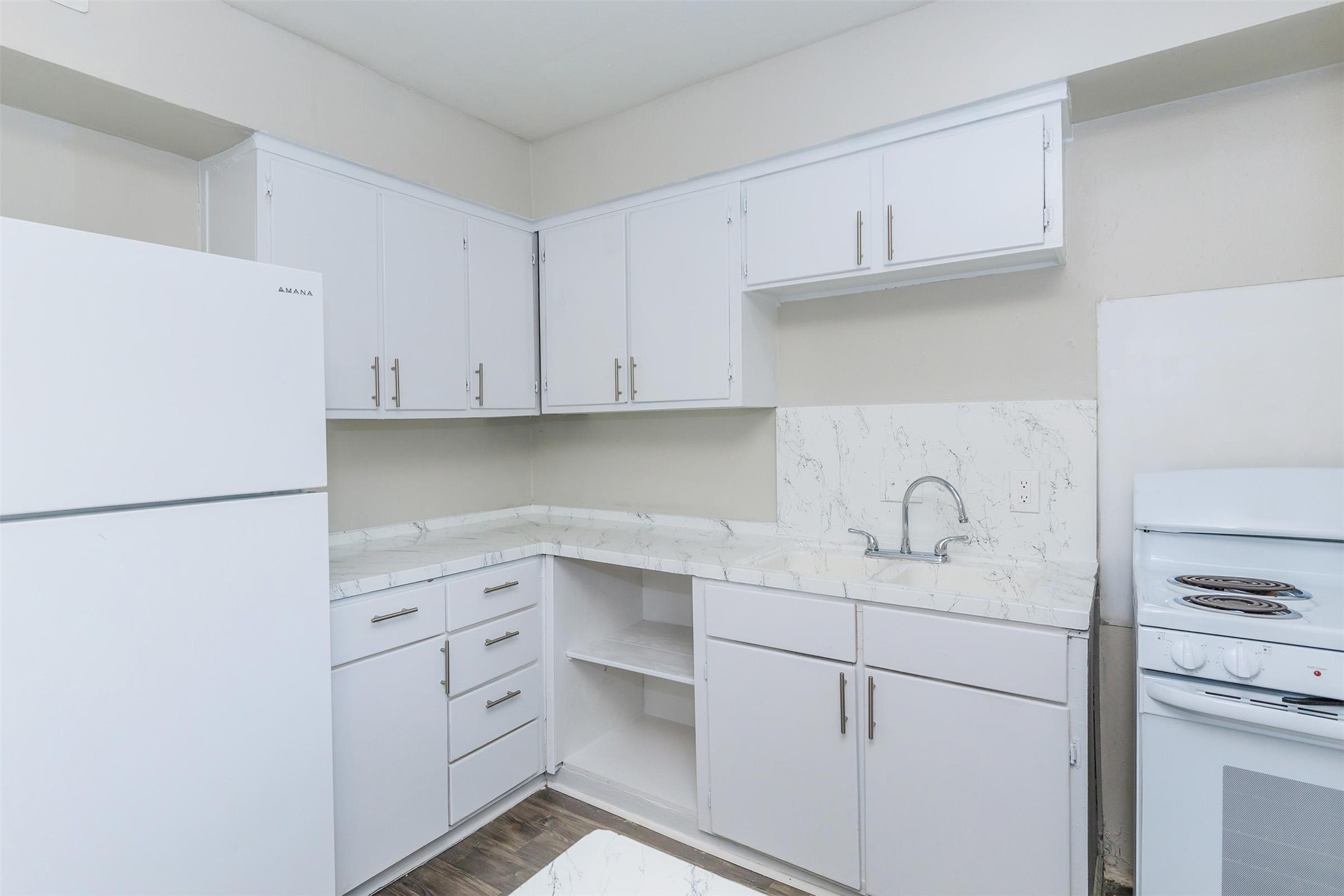 8271 Stone Street, Unit 7140 Houston, TX 77061 - Photo 5 of 28 a kitchen with white cabinets and white appliances