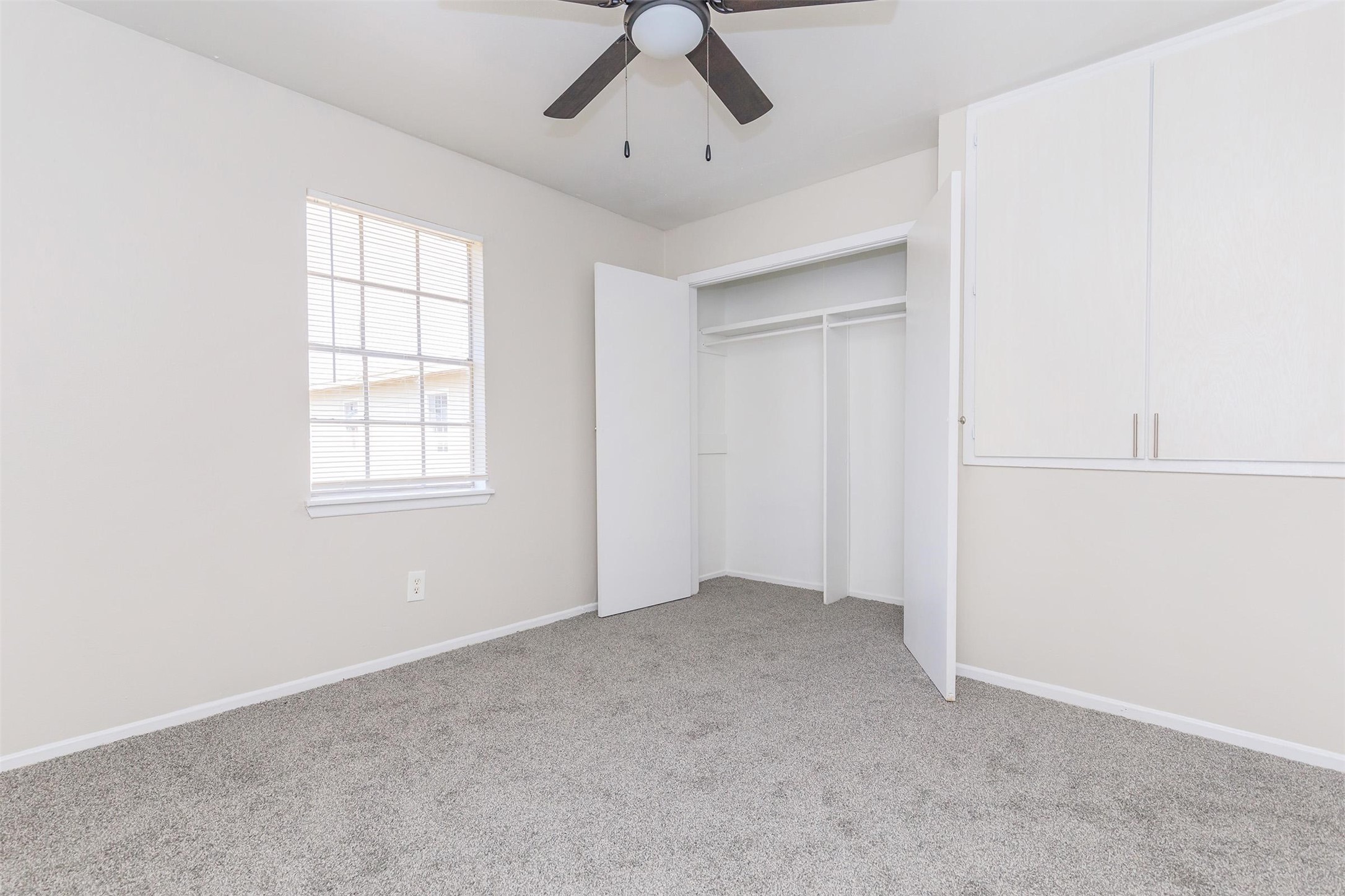 8271 Stone Street, Unit 7140 Houston, TX 77061 - Photo 8 of 28 an empty room with chandelier fan and windows