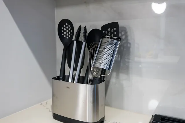 a kitchen with stainless steel appliances a refrigerator a sink and wooden cabinets
