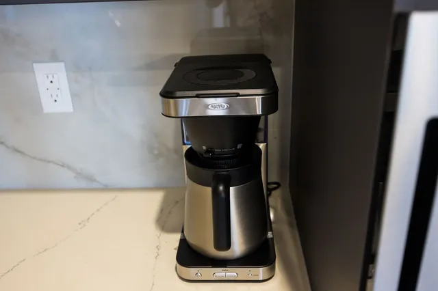 a kitchen with stainless steel appliances granite countertop a sink a stove a refrigerator and island with wooden floor