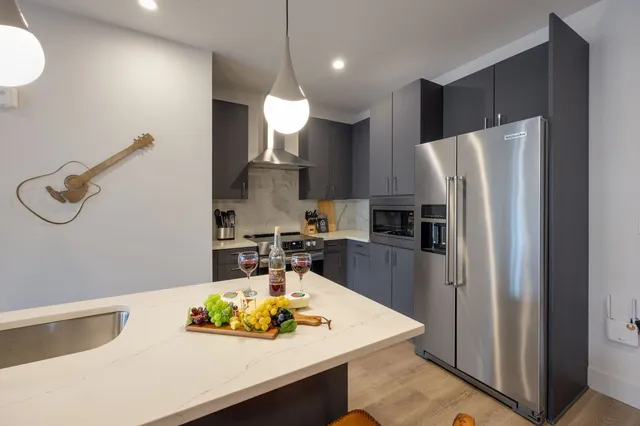 a bathroom with a toilet a sink a mirror a vanity and shower