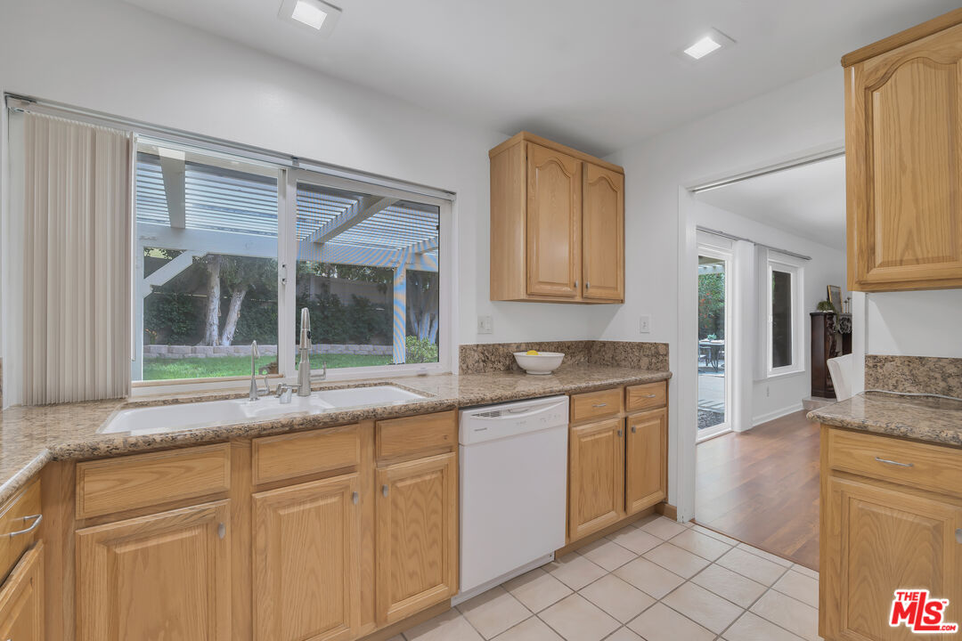 11700 Doral Avenue Porter Ranch, CA 91326 - Photo 17 of 65 a kitchen with granite countertop white cabinets and white appliances