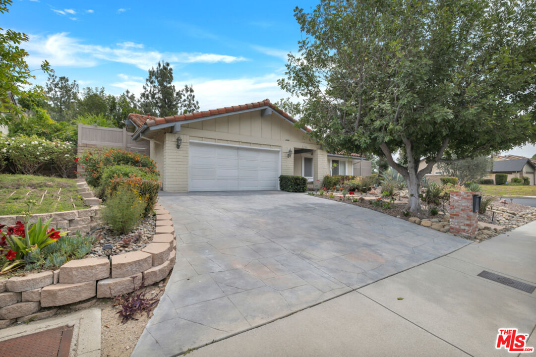 11700 Doral Avenue Porter Ranch, CA 91326 - Photo 56 of 65 a front view of a house with a yard and potted plants