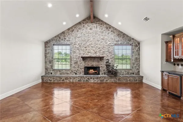 a view of an empty room with a fireplace and a window