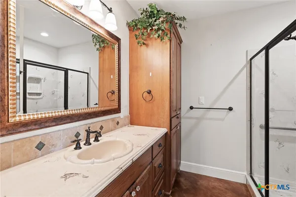 a bathroom with a double vanity sink mirror and shower