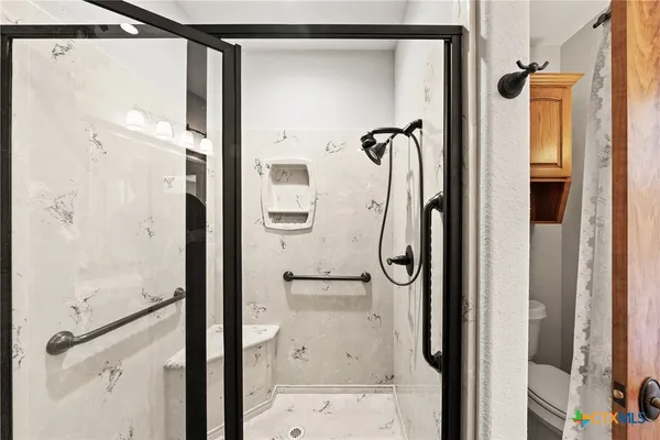 a bathroom with a shower and a glass door