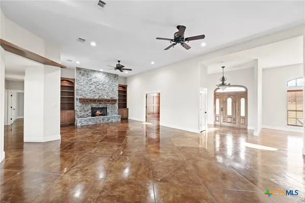 a view of an empty room with window and fireplace