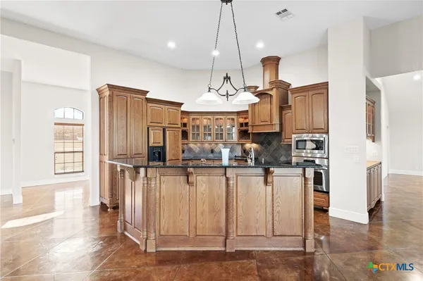 a view of a kitchen with refrigerator and cabinets