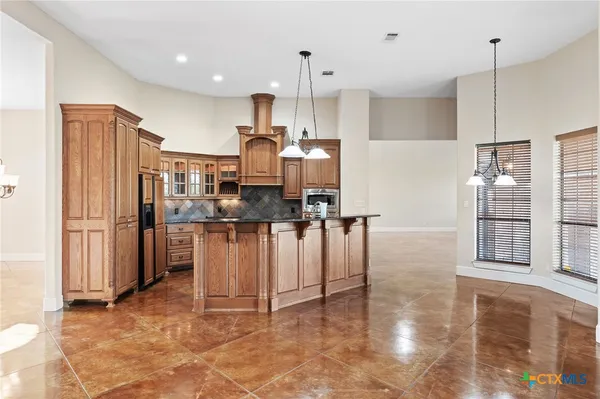 a kitchen with stainless steel appliances a refrigerator and a stove top oven