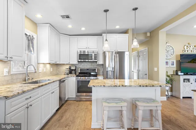a open kitchen with stainless steel appliances granite countertop a stove and refrigerator