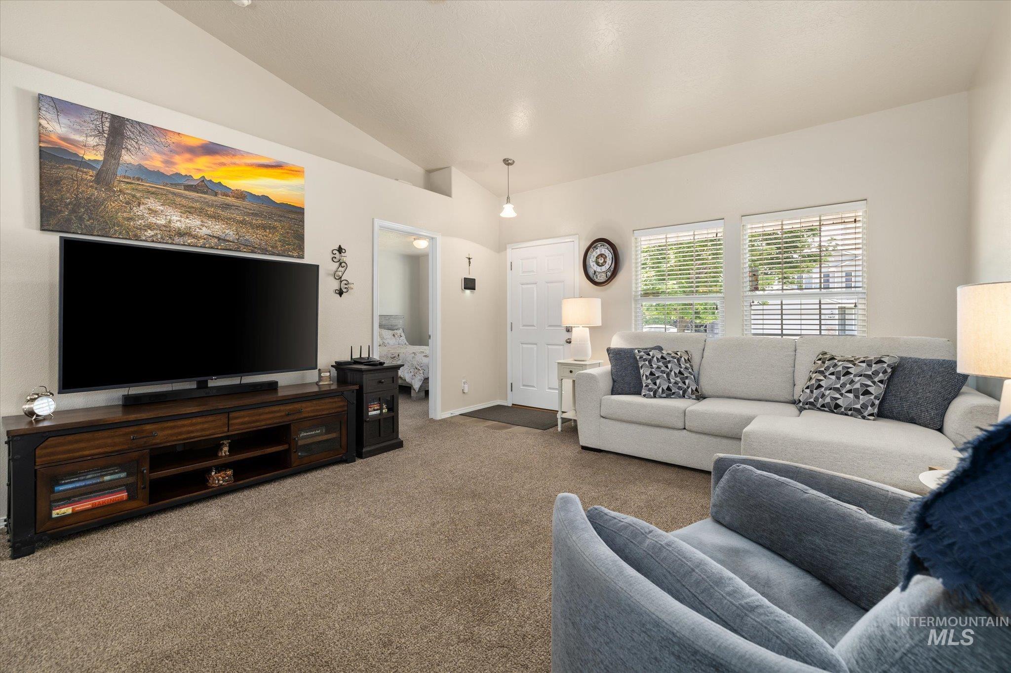5401 Barkley Way Caldwell, ID 83607 - Photo 15 of 35 Spacious living area featuring vaulted ceilings, light-toned wall paint, and plush carpet flooring