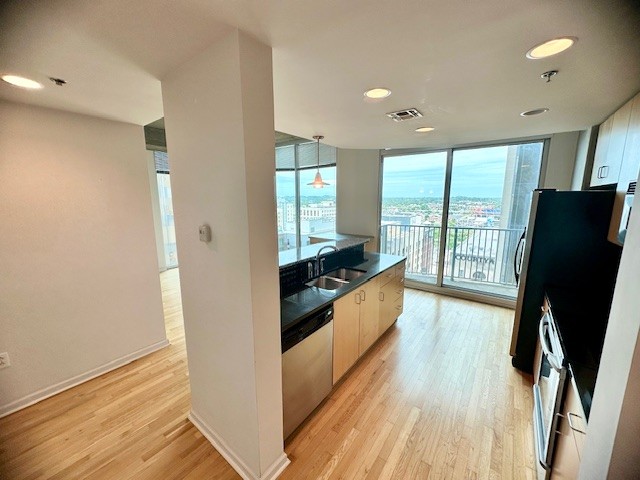 415 Church Street, Unit 1603 Nashville, TN 37219 - Photo 4 of 14 a view of a refrigerator in kitchen and wooden floor