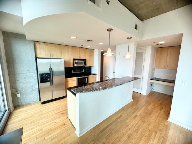 415 Church Street, Unit 1603 Nashville, TN 37219 - Photo 5 of 14 a large kitchen with stainless steel appliances kitchen island a large counter top and wooden floors