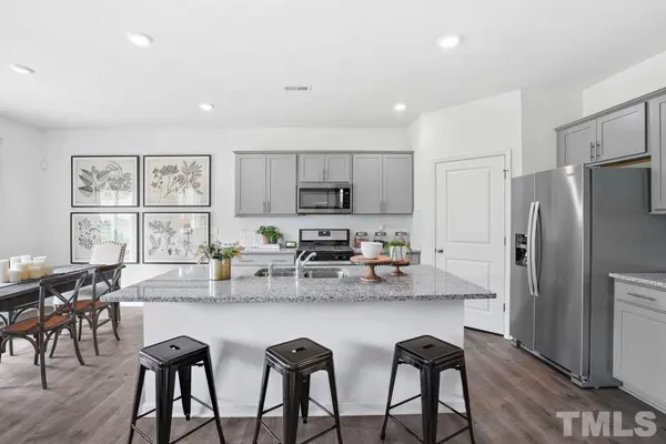 a kitchen with granite countertop white cabinets and stainless steel appliances