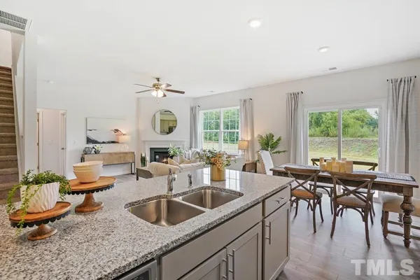 a kitchen with sink and view of living room