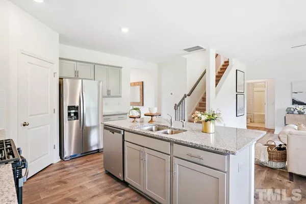 a kitchen with stainless steel appliances granite countertop a sink stove and refrigerator