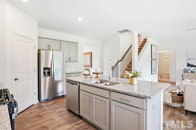 a kitchen with stainless steel appliances granite countertop a sink stove and refrigerator