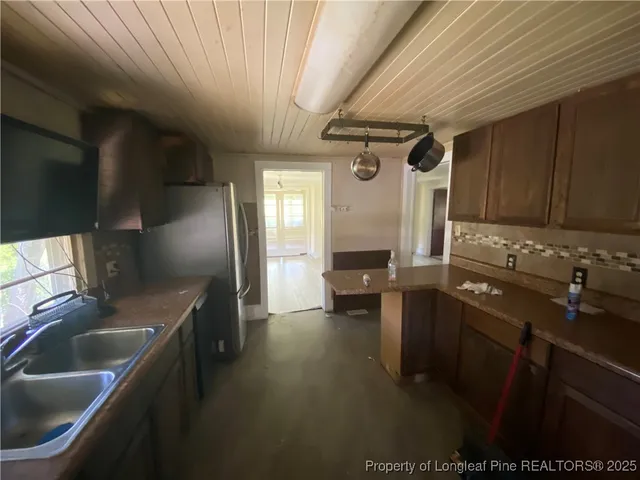 a kitchen with granite countertop a sink stainless steel appliances and cabinets