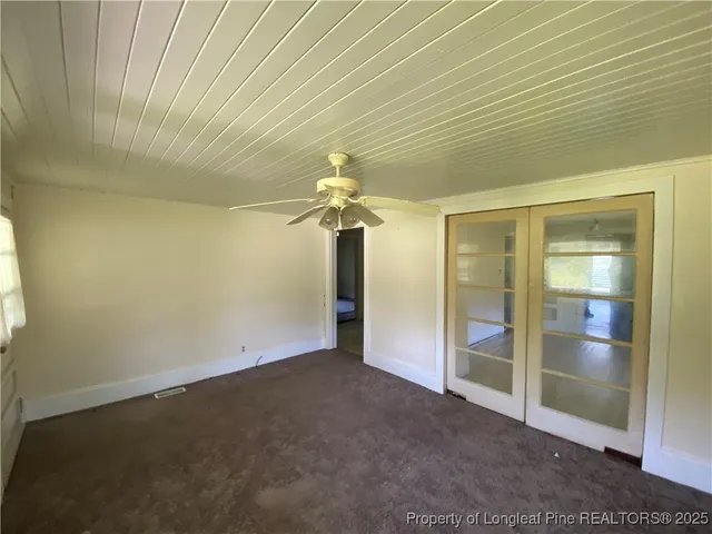 an empty room with chandelier fan