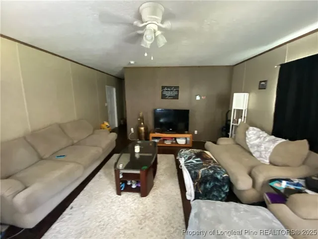 a living room with furniture a flat screen tv and a couch