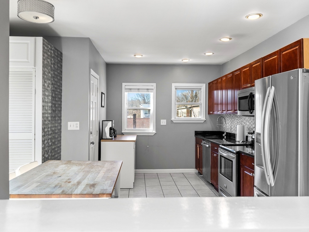 91-93 Rossmore Road, Unit 3 Boston, MA 02130 - Photo 10 of 25 a kitchen with a refrigerator and a stove top oven