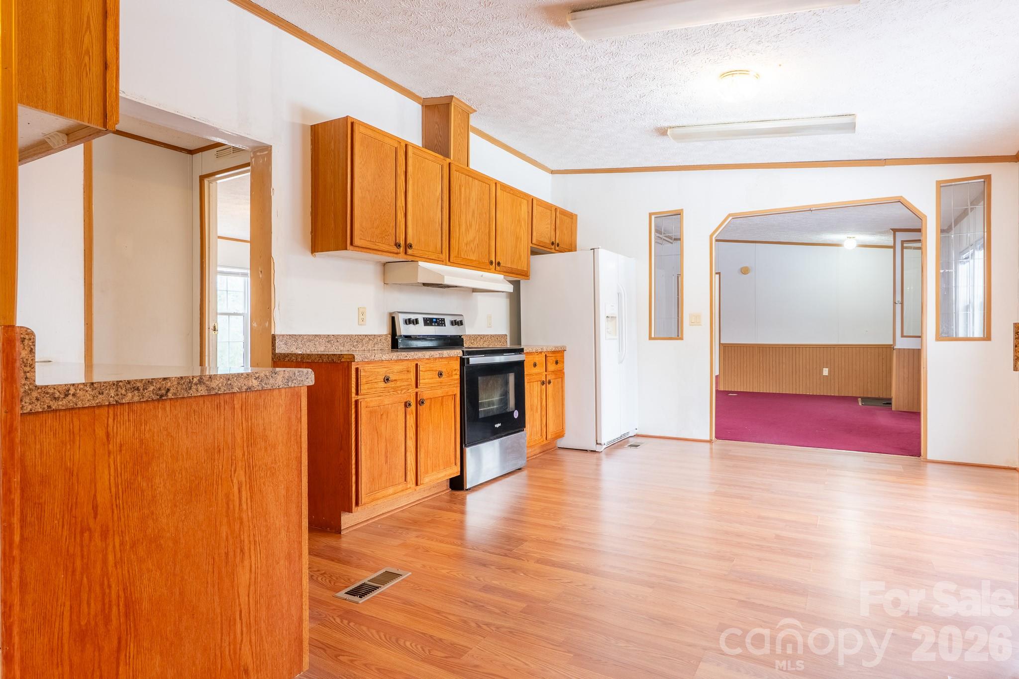8636 County Line Road Hickory, NC 28602 - Photo 8 of 18 a view of a kitchen with a refrigerator cabinets and a wooden floor