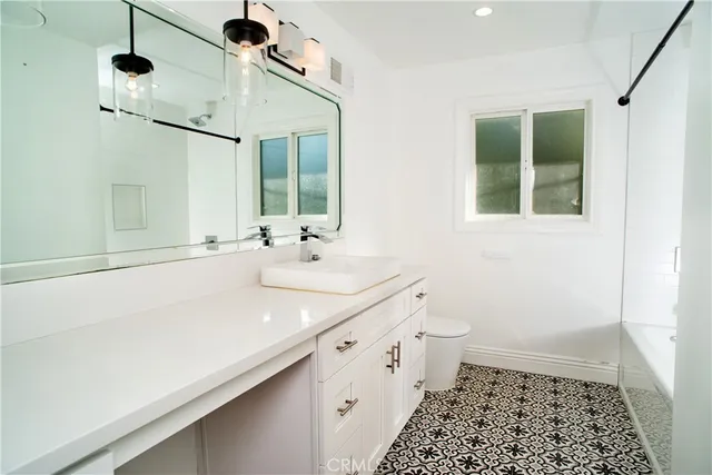 a bathroom with a sink a toilet and a mirror