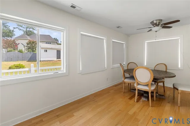 a view of a work space with furniture a potted plant and wooden floor
