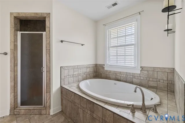 a white bath tub sitting in a bathroom next to a window