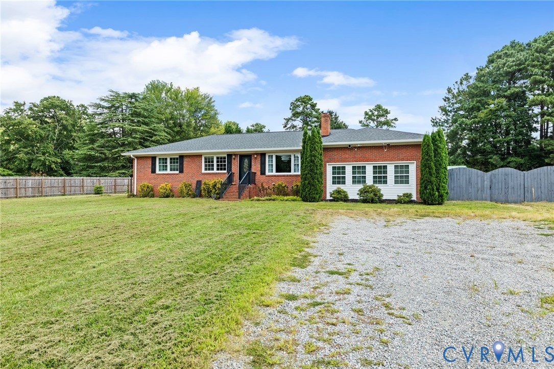 Ranch-style home featuring brick siding, a chimney