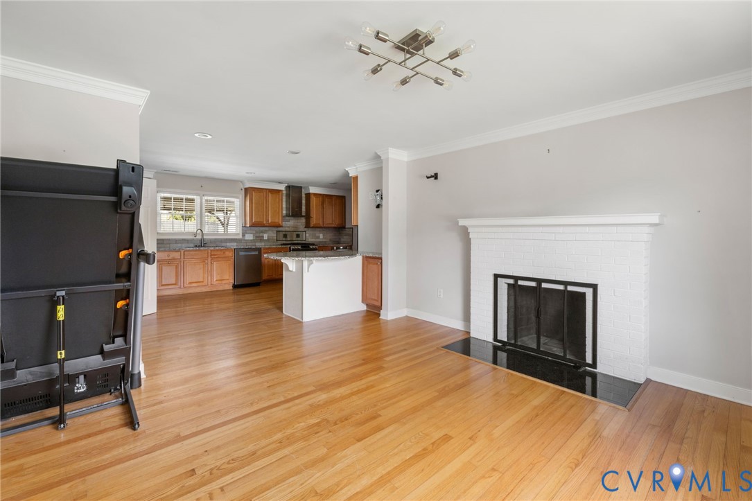 Living room featuring ornamental molding, a firepl