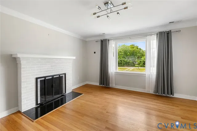 a view of empty room with wooden floor and fireplace