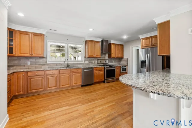 a kitchen with stainless steel appliances granite countertop a sink stove and refrigerator