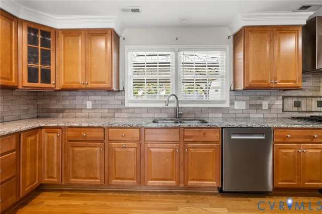 a kitchen with granite countertop wooden cabinets a sink and a window