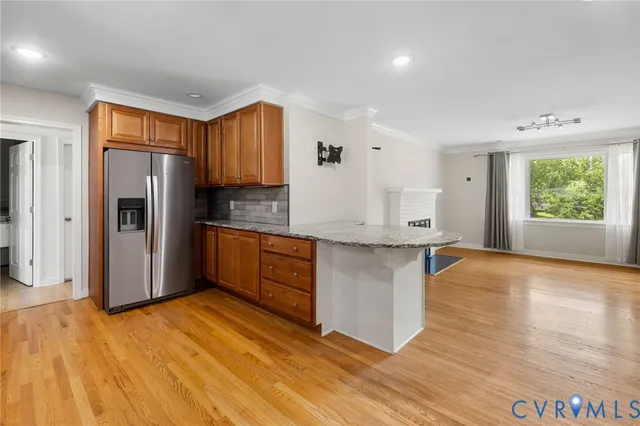 a kitchen with stainless steel appliances granite countertop a refrigerator a sink dishwasher a stove with wooden floor and cabinets