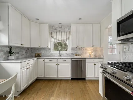 a kitchen with granite countertop white cabinets and white appliances