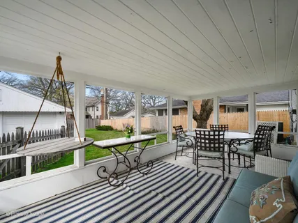 a view of a chairs and table in patio with swimming pool