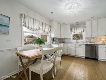 a kitchen with a table chairs sink and cabinets