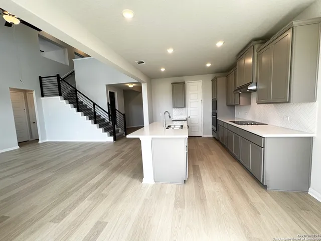 a kitchen with a refrigerator and a stove top oven
