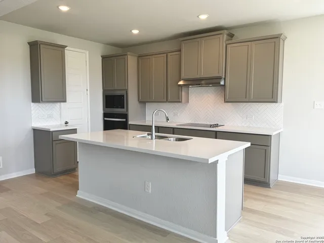 a kitchen with stainless steel appliances a sink stove and cabinets